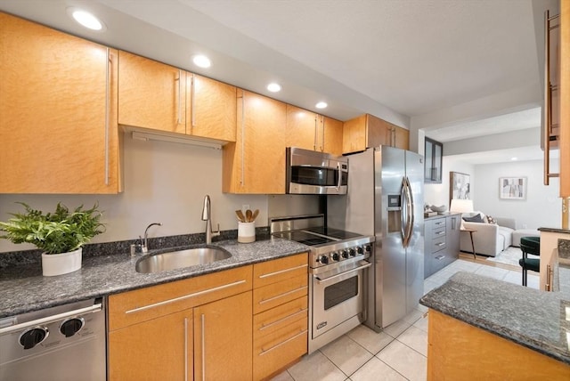 kitchen featuring dark stone countertops, sink, light tile patterned floors, and stainless steel appliances