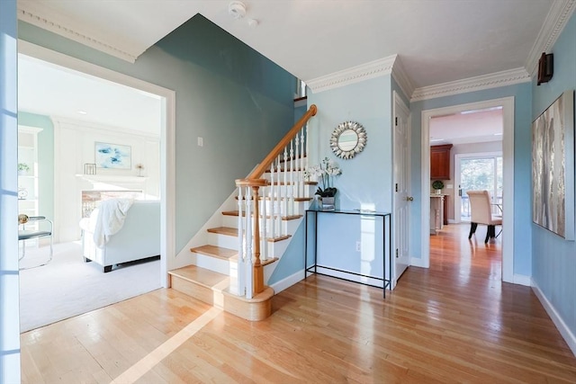 stairway with crown molding and hardwood / wood-style floors