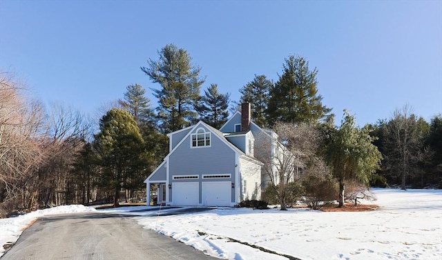 view of snow covered exterior featuring a garage