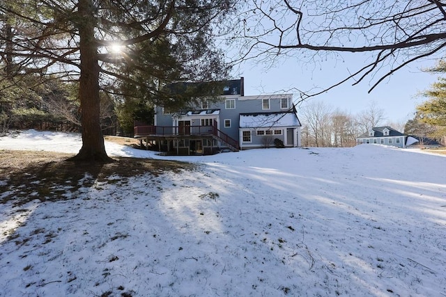 snow covered house featuring a deck