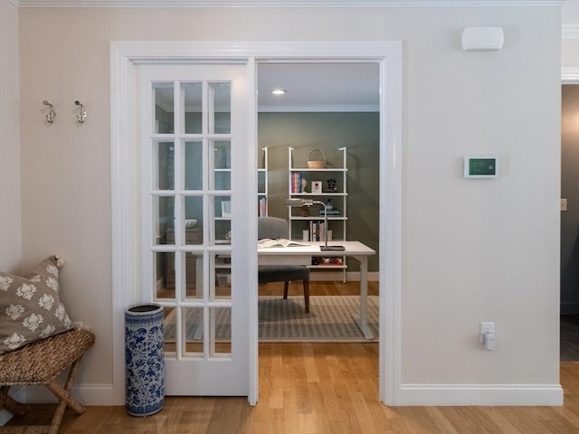 entryway featuring ornamental molding and light hardwood / wood-style flooring