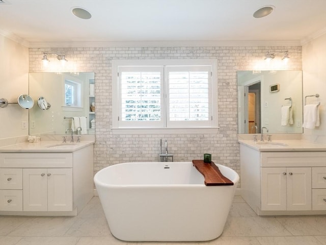 bathroom featuring a wealth of natural light, crown molding, a tub to relax in, and vanity