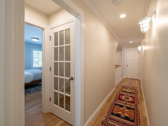 corridor with crown molding and light wood-type flooring