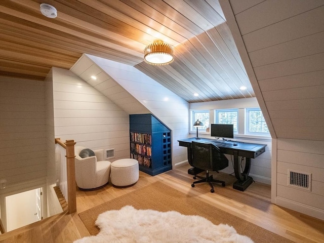 office space featuring lofted ceiling, light wood-type flooring, wood ceiling, and wood walls