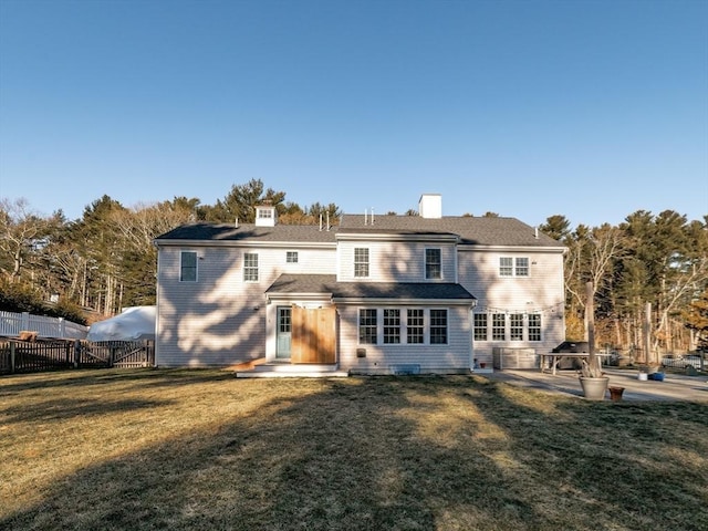 back of house with a patio area and a lawn