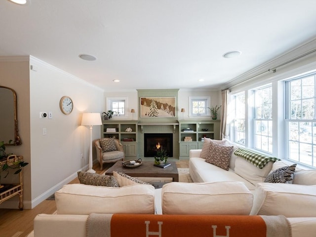 living room featuring light wood-type flooring, a fireplace, and crown molding