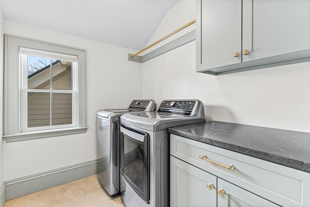 washroom featuring light tile patterned floors, washing machine and dryer, and cabinets