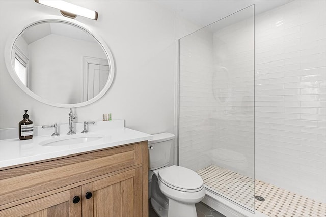 bathroom featuring vanity, toilet, and tiled shower