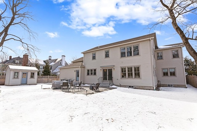 snow covered rear of property with an outbuilding