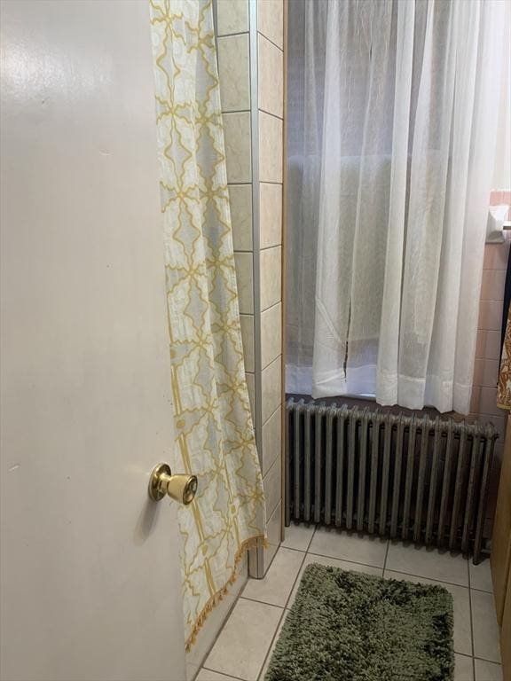 295 Grove St, Brockton, MA 02302 - full bath with radiator, tile patterned flooring, and shower / bath combo with shower curtain