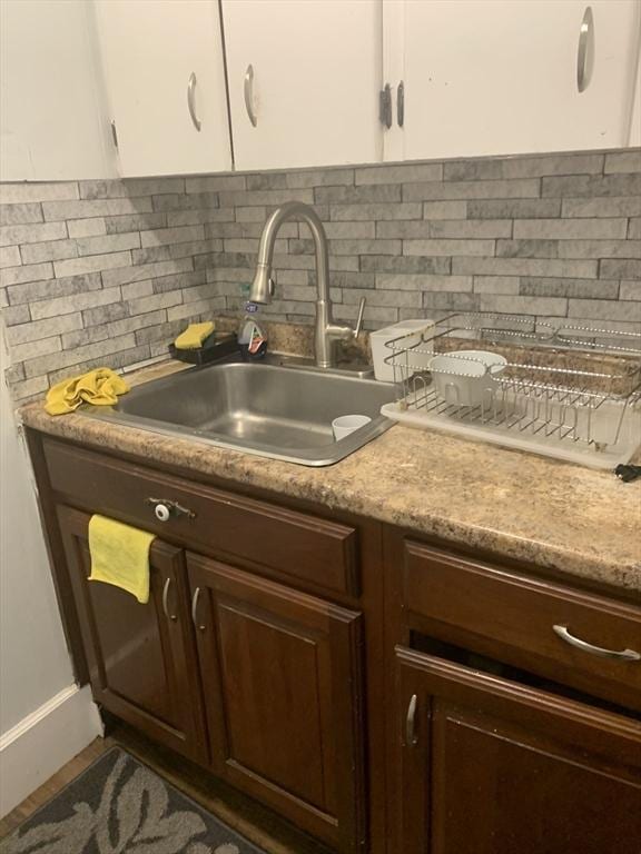 295 Grove St, Brockton, MA 02302 - kitchen view of a sink, tasteful backsplash, light countertops, and white cabinetry