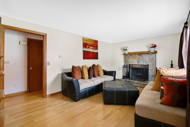 living area featuring a fireplace, wood finished floors, and baseboards