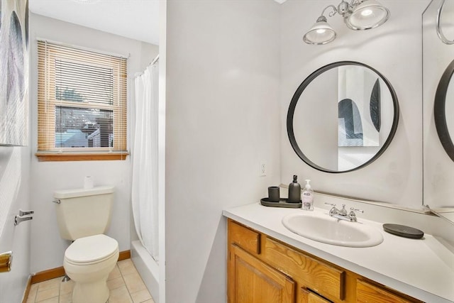 bathroom with tile patterned flooring, toilet, vanity, baseboards, and a shower stall