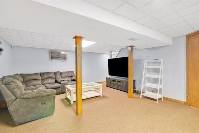 carpeted living area with a paneled ceiling and baseboards