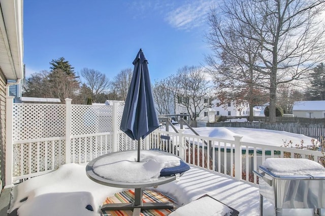 snow covered deck featuring fence