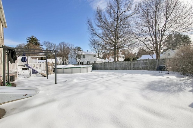 snowy yard with a fenced in pool, fence, and a pergola