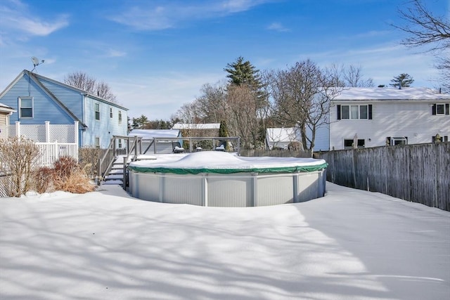 yard layered in snow featuring fence and a fenced in pool