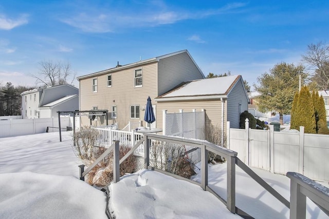 snow covered property with fence and a wooden deck