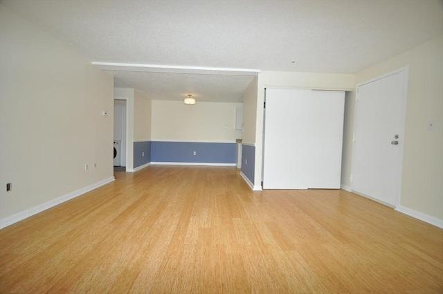 spare room with light wood-style floors and baseboards