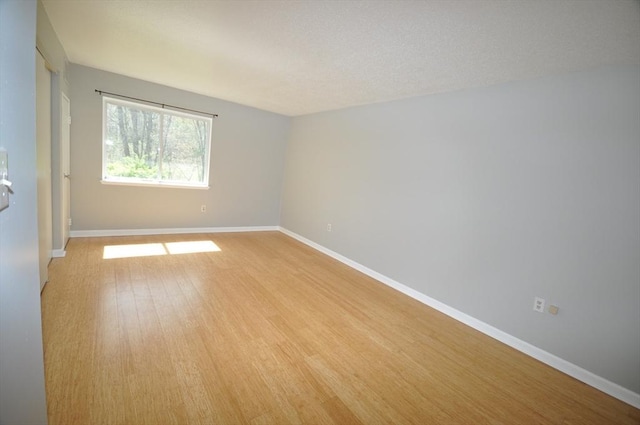 unfurnished room featuring baseboards and light wood-style flooring