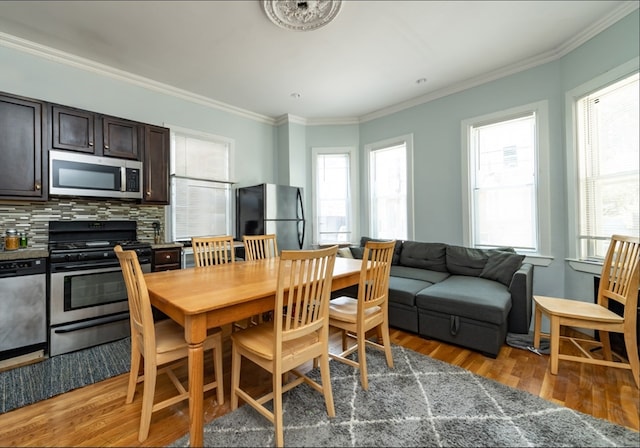 dining area featuring hardwood / wood-style flooring and crown molding