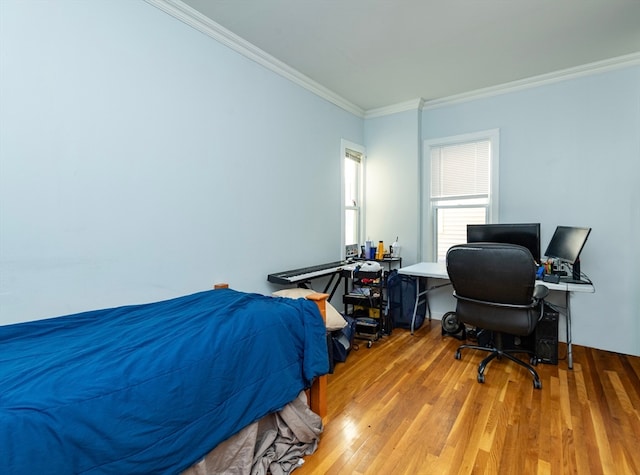 bedroom with ornamental molding and light wood-type flooring