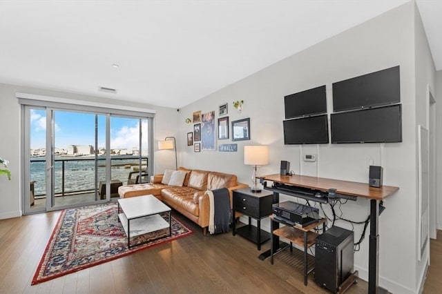 living room with dark hardwood / wood-style floors and a water view