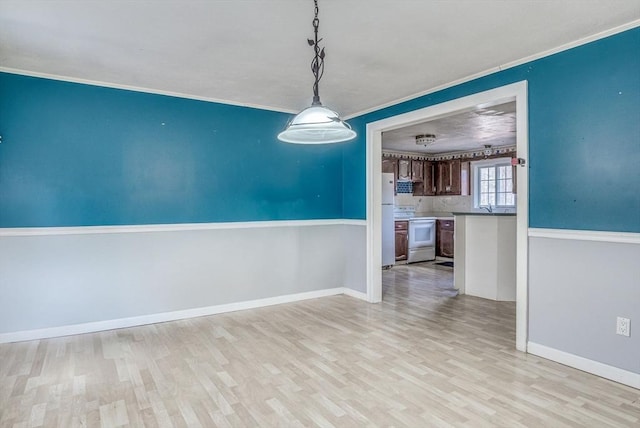 unfurnished dining area with light wood-type flooring and ornamental molding