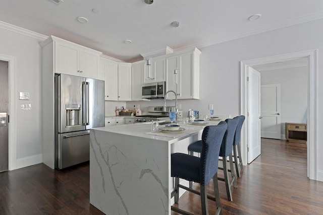 kitchen featuring appliances with stainless steel finishes, a kitchen breakfast bar, crown molding, white cabinets, and hanging light fixtures