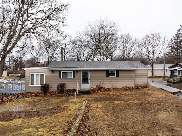 single story home featuring a deck and a front lawn