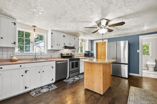 66 Squantum Rd, Jaffrey, NH 03452 - kitchen with appliances with stainless steel finishes, dark wood-type flooring, range hood, white cabinets, and decorative backsplash