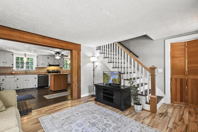 66 Squantum Rd, Jaffrey, NH 03452 - living area featuring a textured ceiling, wood finished floors, stairs, and ceiling fan