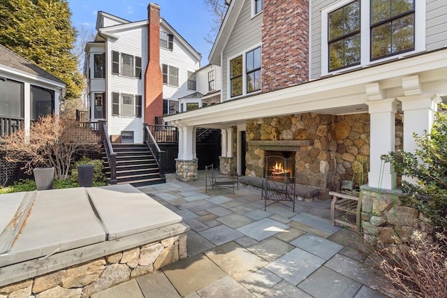 view of patio / terrace featuring stairway and an outdoor stone fireplace