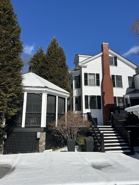 snow covered property featuring stairway