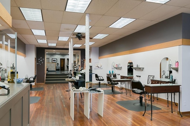 interior space with hardwood / wood-style flooring, a paneled ceiling, and baseboards