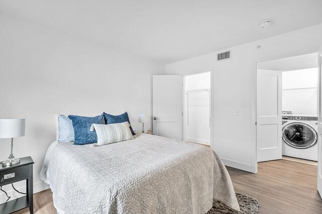 bedroom featuring washer / clothes dryer and hardwood / wood-style flooring