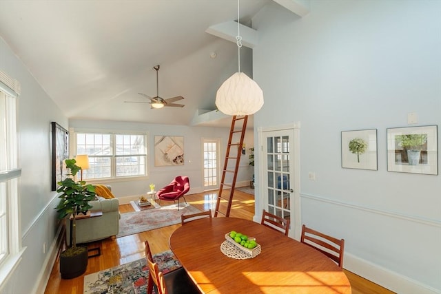 dining space with high vaulted ceiling, hardwood / wood-style floors, and ceiling fan