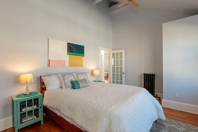 bedroom featuring ceiling fan, high vaulted ceiling, radiator, and hardwood / wood-style flooring