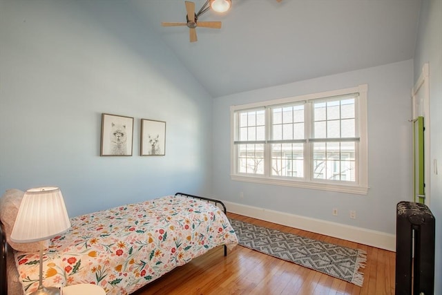 bedroom featuring ceiling fan, radiator heating unit, lofted ceiling, and wood-type flooring