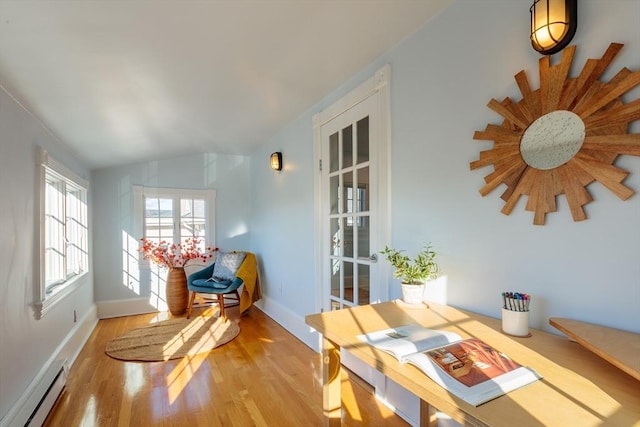 sunroom featuring a baseboard heating unit and lofted ceiling