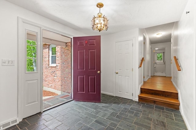 12 Queens Cir, Sharon, MA 02067 - entryway with a chandelier, plenty of natural light, and dark stone finish flooring