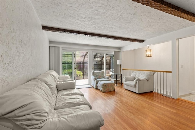 12 Queens Cir, Sharon, MA 02067 - living area featuring light wood-style flooring, a textured wall, a textured ceiling, and beam ceiling