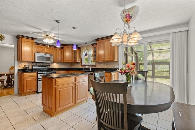 12 Queens Cir, Sharon, MA 02067 - kitchen featuring appliances with stainless steel finishes, plenty of natural light, tasteful backsplash, light tile patterned floors, and a textured ceiling