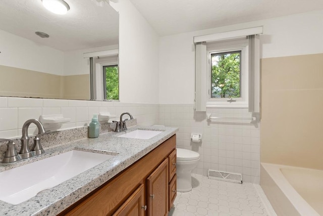12 Queens Cir, Sharon, MA 02067 - full bathroom featuring tile walls, tile patterned flooring, toilet, a tub to relax in, and wainscoting