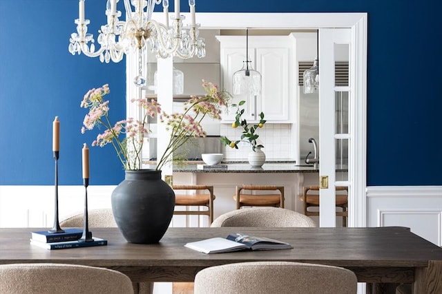 dining space with a wainscoted wall