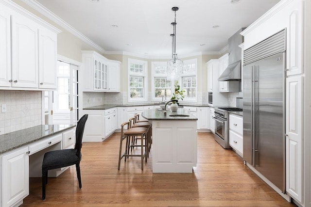 kitchen featuring white cabinetry, crown molding, a breakfast bar area, and high quality appliances