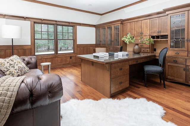 office space with light wood-style floors, lofted ceiling, a wainscoted wall, and ornamental molding