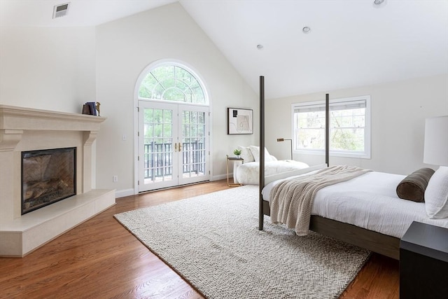 bedroom with access to outside, multiple windows, visible vents, and wood finished floors