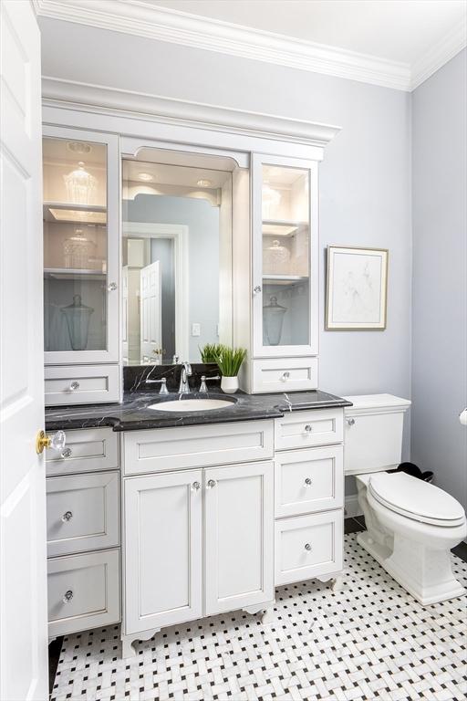 bathroom featuring ornamental molding, vanity, and toilet