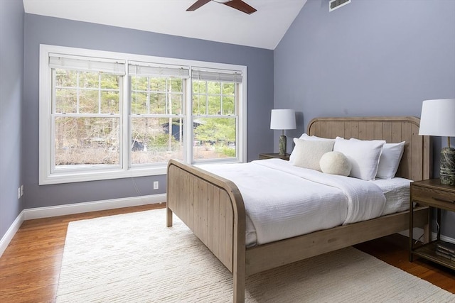 bedroom featuring lofted ceiling, light wood finished floors, visible vents, and baseboards